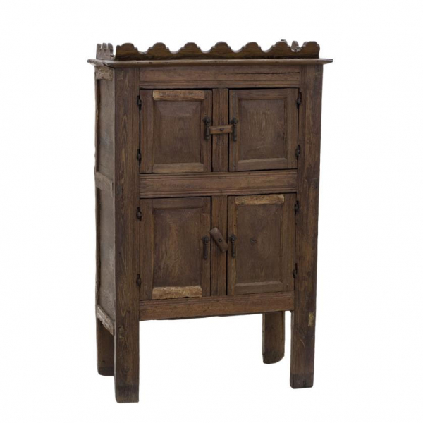 Alacena de estilo castellano popular en madera tallada, posiblemente de pino. Herrajes en hierro recortado. Con armario en parte superior e inferior. S. XVII o posterior.