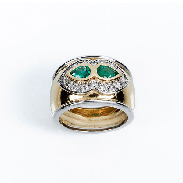 Anillo en sólida montura de oro amarillo y blanco 18 K con dos bonitas esmeraldas talla perilla, orladas de limpios y blancos diamantes, talla brillante