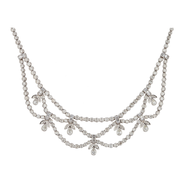 Espléndida gargantilla tipo rivière en oro blanco con centro acabado en ondas y hojitas de diamantes talla brillante, lágrimas de diamantes talla perilla y entrepiezas de diamantes talla trapecio engastados en barras y chatón.