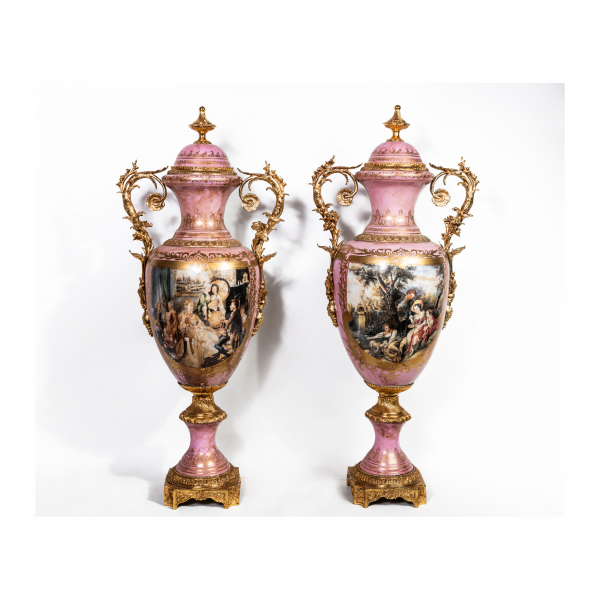 Pareja de jarrones estilo Sèvres en porcelana esmaltada y parcialmente dorada con aplicaciones en bronce dorado con escenas cortesanas en reservas sobre fondo de tonalidad rosa, s.XX.