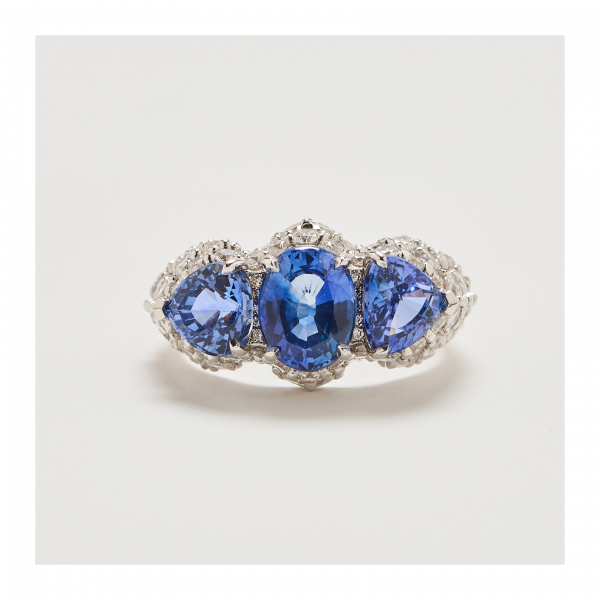 Sortija en oro blanco con tres zafiros azules tallas oval y trillón y diamantes talla brillante. Peso diamantes: 1,25 ct. aprox.