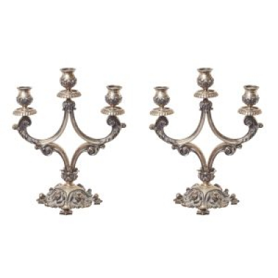 Pareja de candelabros de tres luces en plata punzonada con decoraciones gallonadas, de roleos y acantos, s.XX.
