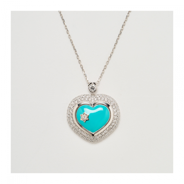 Colgante diseño corazón en oro blanco con cabujón de turquesa talla corazón y tres orlas de diamantes talla brillante.