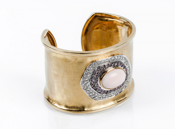 Brazalete esclavo ancho en oro amarillo con vistas matizadas artesanales, y centro en cabujón oval de coral 'piel de ángel',