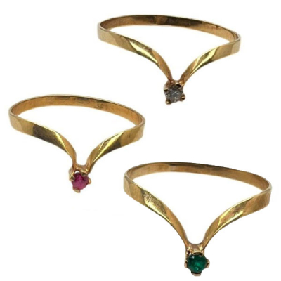 Tres sortijas con piedras preciosas que presentan un diseño en pico con rubí, esmeralda y circonita talla redonda engastados en garras.