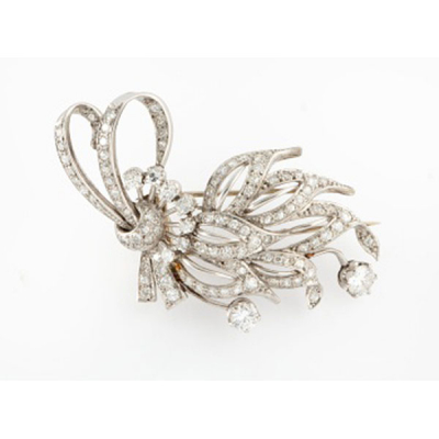 Broche en platino formando lazo con 9 diamantes talla brillante y con cuajado de diamantes talla brillante con un peso total de 2 cts. aprox.
