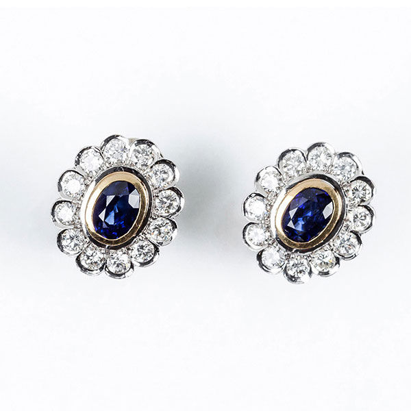 Pendientes en oro amarillo 18 K, con un zafiro fino, azul, oval y orla de limpios y blancos diamantes 