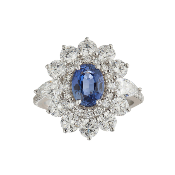 Sortija rosetón en oro blanco con zafiro azul talla oval y doble orla y brazos de diamantes tallas brillante y perilla.