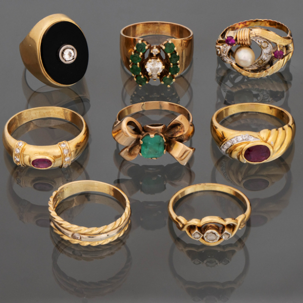 Conjunto de ocho anillos en oro amarillo de 18kt con esmeraldas, brillantes, esmalte negro y rubíes.