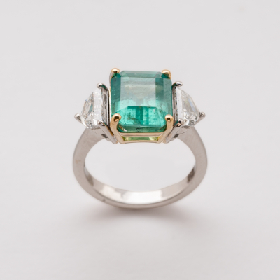 Sortija en oro bicolor con esmeralda colombiana talla octogonal custodiada por diamantes talla escudo.