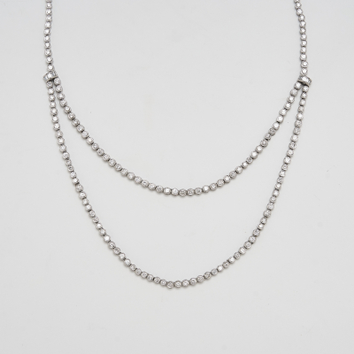 Gargantilla tipo rivière en oro blanco con dos tiras centrales de diamantes talla brillante engastados en chatón y unidas por motivos de diamantes talla baguette.