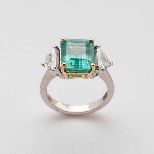 Sortija en oro bicolor con esmeralda colombiana talla octogonal custodiada por diamantes talla escudo.