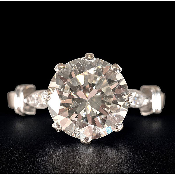 Anillo solitario con diamante central de talla brillante de 3,95 ct , color K y pureza SI con diamantes laterales. 