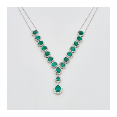 Gargantilla en oro blanco con rosetones de esmeraldas colombianas tallas oval y perilla orladas por diamantes talla brillante.