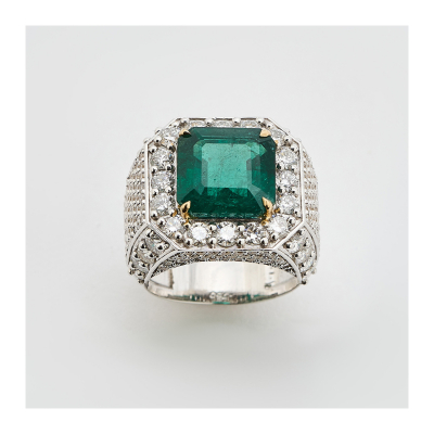 Sortija diseño sello en oro bicolor con esmeralda central talla octogonal y cuerpo cuajado de diamantes talla brillante.