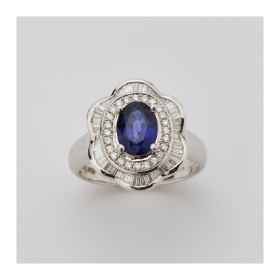 Sortija rosetón en oro blanco con zafiro azul talla oval orlado por diamantes talla brillante y bailarina de diamantes talla trapecio engastados en barras.