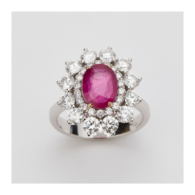 Sortija rosetón en oro blanco con rubí central talla oval y doble orla de diamantes talla brillante.