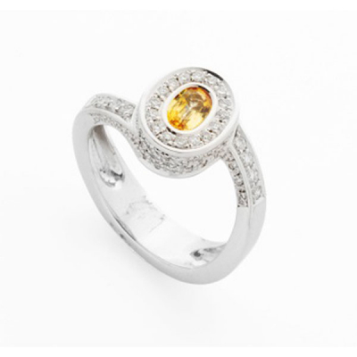 Sortija en oro blanco con zafiro amarillo central, orla de diamantes 