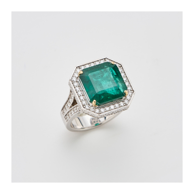 Sortija en oro blanco con esmeralda de Zambia talla octogonal, orla y brazos calados de diamantes talla brillante.