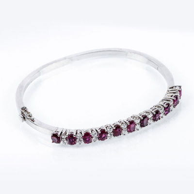 Brazalete esclavo vintage de alta joyer&iacute;a, en s&oacute;lida montura de oro blanco 18 K, con motivo en fila de bellos rub&iacute;es naturales de intenso color, talla oval, alternados con pares de limpios y blancos diamantes naturales 