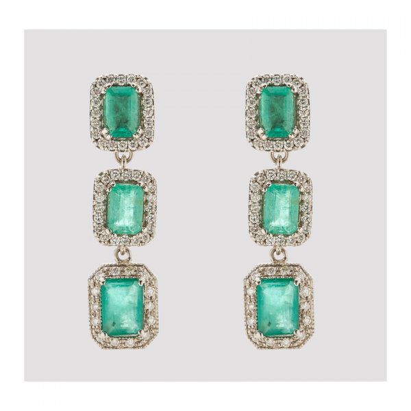 Pendientes largos en oro blanco con tres rosetones de esmeralda talla octogonal orladas por diamantes talla brillante.