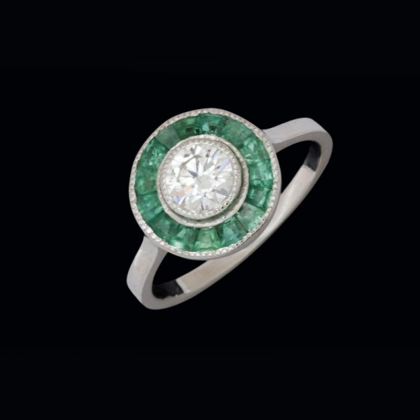 Anillo de oro blanco de 18 K. ojo de perdiz con brillante de 0,48 cts. y esmeraldas calibradas (0,25 cts.).