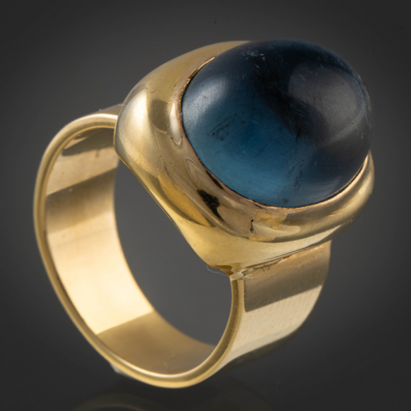 Anillo en oro amarillo de 18kt con piedra central color azul en cabujón.