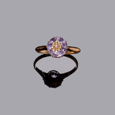 Sortija vintage en oro rosa con una piedra amatista circular, en garras, y centro incrustado de flor decorada con media perlita.
