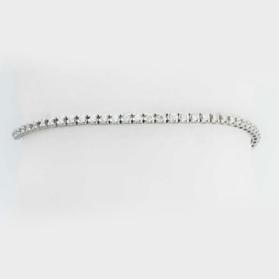 Bonita pulsera riviere en montura de oro blanco, con fila articulada de limpios y blancos diamantes, talla brillante, montados en garritasl (70 bts: 1.80 ct aprox.