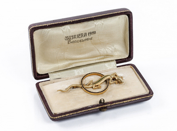 Alfiler antiguo 'art nouveau' en oro amarillo con motivo de lagarto con banda de peridotos calibrados, y un aro calado con decoración de esmaltes negros.C 1900.