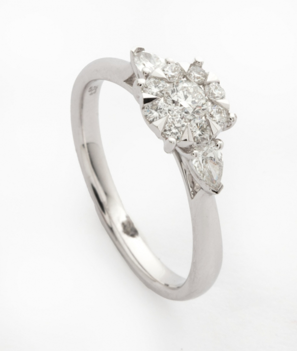 Sortija en oro blanco con cuajado central de diamantes talla brillante y 2 diamantes talla princesa