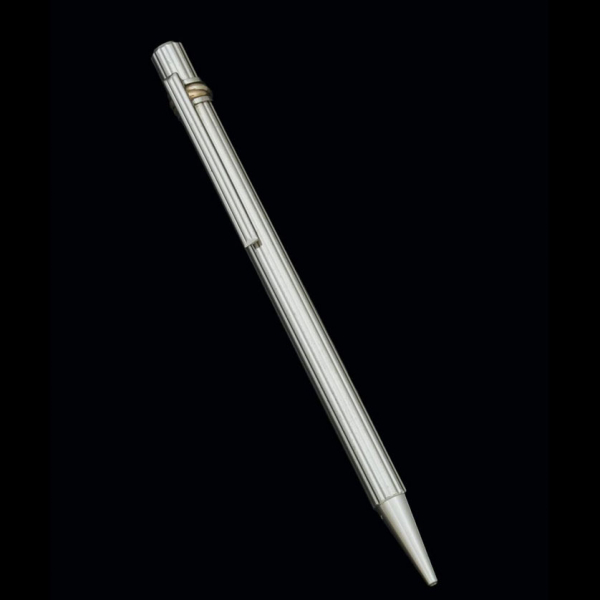 Bolígrafo marsca CARTIER, modelo Must, realizado en plata con decoración lineal y aros de oro tricolor.