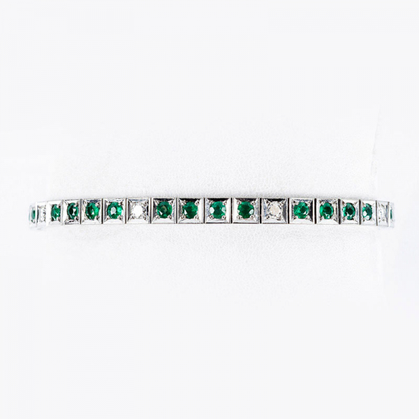 Pulsera riviere vintage en sólida montura de oro blanco 18 K, con fila articulada de esmeralditas en tramos alternados con limpios y blancos diamantes, talla brillante