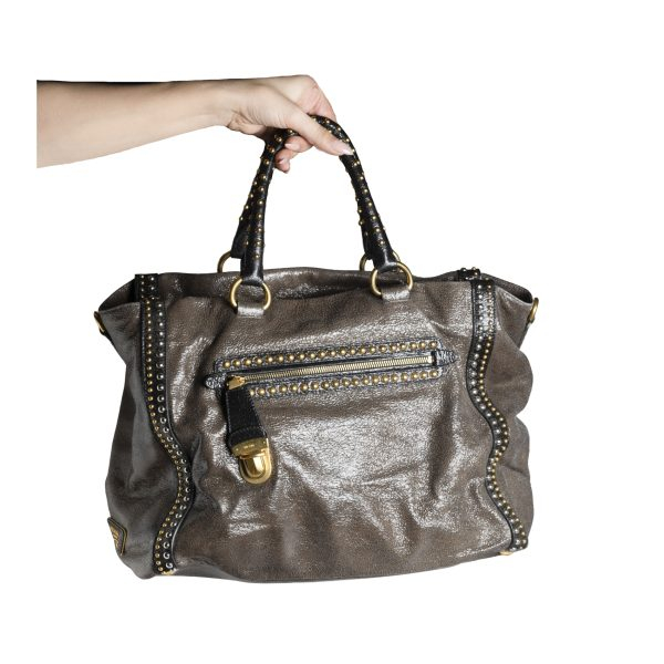 PRADA. Bolso modelo «Studded Craquele» en piel metalizada con herrajes, tachuelas y remaches en metal dorado y plateado. 