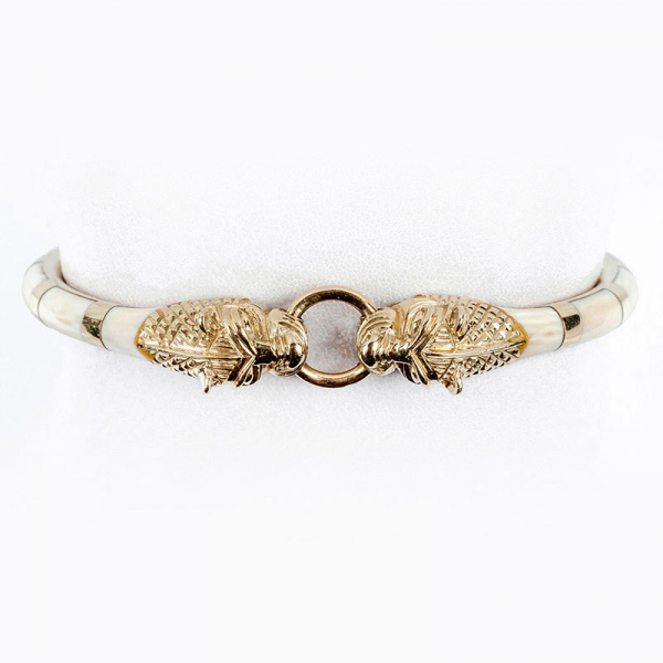 Pulsera esclava vintage de excelente factura, en sólida montura de oro amarillo con incrustaciones de dentina natural. Motivo de cabezas de felino enfrentadas.