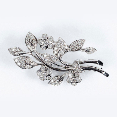 Broche-alfiler en s&oacute;lida montura de oro blanco 18 K, con motivo de ramo de flores y blancos diamantes talla brillante