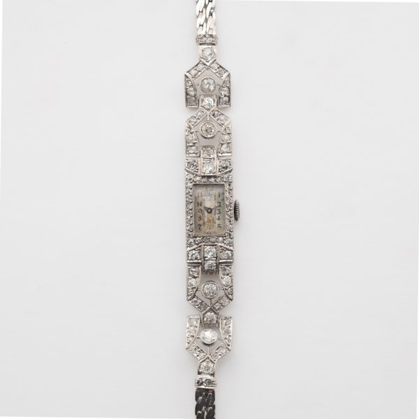 CYMA. Reloj Art Decó de pulsera para señora en platino con armis de doble trenza plana (realizado posteriormente) en oro blanco.