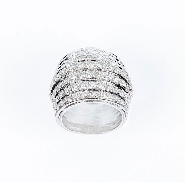 Sortija ancha en sólida montura de oro blanco, diseño 'bombé' en bandas escalonadas en fila de limpios y blancos diamantes talla brillante