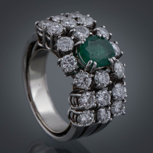 Anillo de diamantes y esmeralda central.