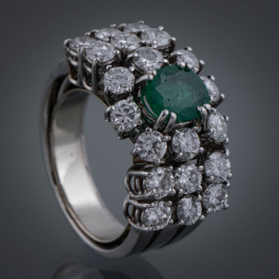 Anillo de diamantes y esmeralda central.