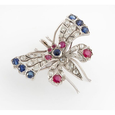 Broche-colgante en oro blanco representando mariposa con 7 zafiros, 6 rubíes y 27 diamantes talla brillante