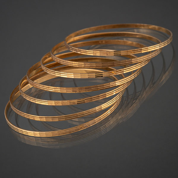 Conjunto de siete pulseras rígidas con decoración ajedrezada en el perfil.