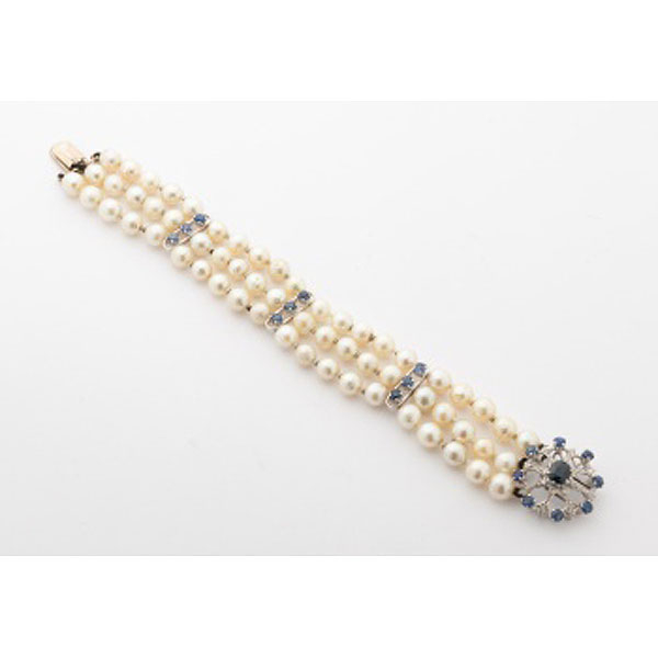 Pulsera en oro blanco con 3 filas de perlas cultivadas y 3 barras con 9 zafiros azules, cierre en forma de flor con zafiro central
