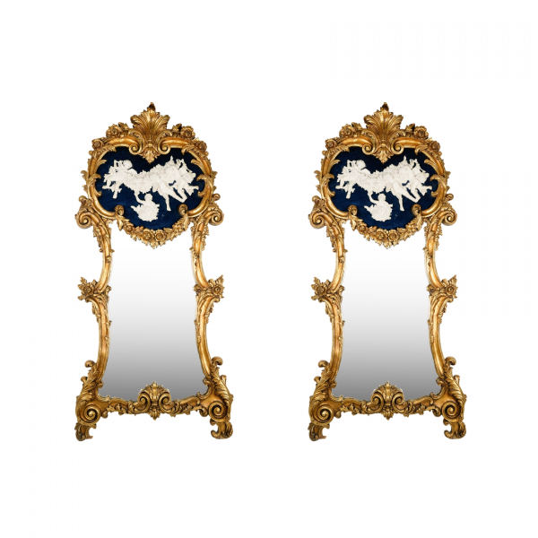 Pareja de espejos «Trumeau» en pasta de madera dorada con copete decorado por querubines en relieve 