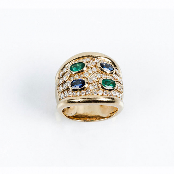 Sortija ancha en sólida montura de oro amarillo 18 K, con zafiros finos azules y esmeraldas talla oval 