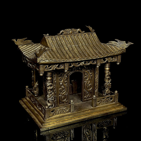 Pequeño templo de madera tallada, arquitectura china con columnas adornadas con imágenes de dragones en relieve, frisos calados y muros decorados con roleos florales.