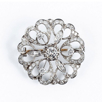 Alfiler vintage en oro blanco con motivo de rosetón calado, cuajado de limpios y blancos diamantes, talla brillante, y centro en garras de ilusión
