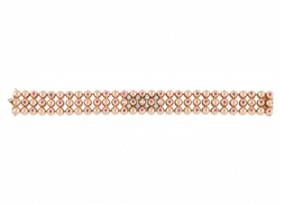Brazalete a&ntilde;os 40 de tres bandas de semiesferas, decoradas con rub&iacute;es y con ocho brillantes en el frente.   En montura de oro rosa 18K.