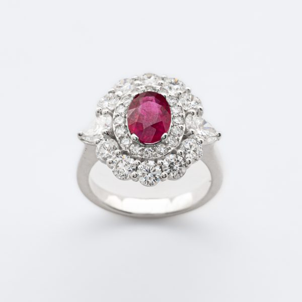 Sortija roset&oacute;n en oro blanco con rub&iacute; (Burma) talla oval y doble orla de diamantes talla brillante custodiados por diamantes talla trill&oacute;n.