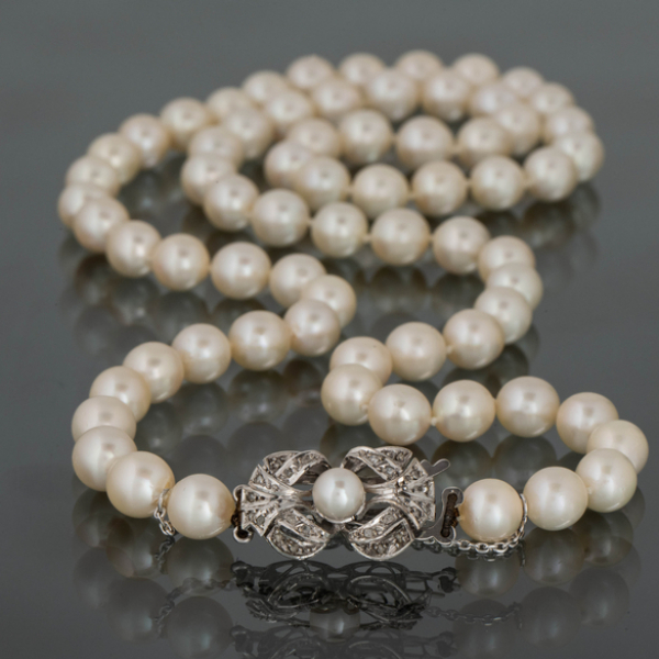 Collar de perlas cultivadas de 0,5cm con broche en oro blanco de 18k con brillantes y perla en el centro.